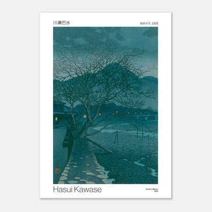 Estampe ancienne : Soirée à Beppu par Hasui Kawase (42x59,4 cm (A2)). Estampe japonaise représentant un paysage crépusculaire avec un arbre dénudé sur une route pavée, des maisons éclairées et des collines en arrière-plan, par Hasui Kawase.