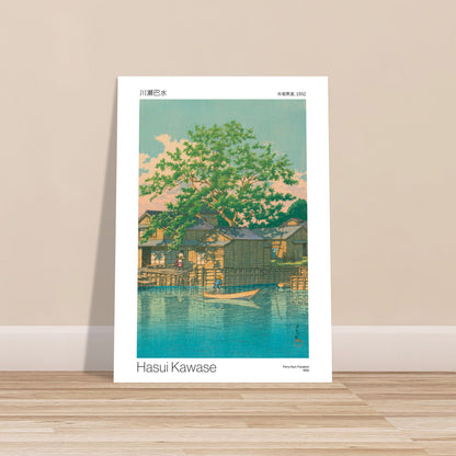 Estampe japonaise : Ferry Kuri à Funabori, par Hasui Kawase. Une estampe japonaise de Hasui Kawase représentant le ferry Kuri à Funabori en 1932, avec des maisons en bois au bord de l'eau sous un grand arbre verdoyant. Image d'illustration 9