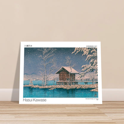 Estampe Sanctuaire Kansagu au Lac Tazawa par Hasui Kawase. Estampe japonaise de Hasui Kawase montrant un paysage hivernal avec un petit bâtiment sur une île au milieu d'un lac, sous une chute de neige. Image d'illustration 7