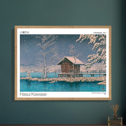 Estampe Sanctuaire Kansagu au Lac Tazawa par Hasui Kawase. Estampe japonaise de Hasui Kawase montrant un paysage hivernal avec un petit bâtiment sur une île au milieu d'un lac, sous une chute de neige. Image d'illustration 8
