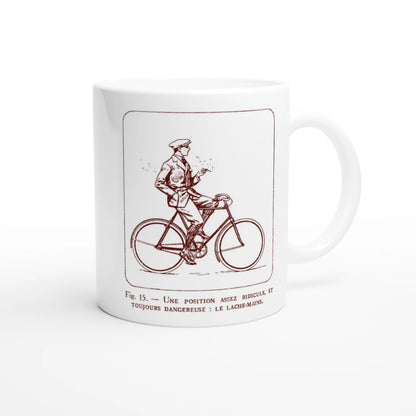 Antica illustrazione di ciclista: Il senza mani. Tazza bianca decorata con un'illustrazione retrò monocroma rossa che raffigura un ciclista in abito che lascia il manubrio, accompagnata dalla didascalia esplicativa 'Une position assez ridicule et toujours dangereuse : le lâche-mains'.