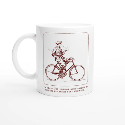 Antica illustrazione di ciclista: Il senza mani. Tazza bianca decorata con un'illustrazione retrò monocroma rossa che raffigura un ciclista in abito che lascia il manubrio, accompagnata dalla didascalia esplicativa 'Une position assez ridicule et toujours dangereuse : le lâche-mains'.