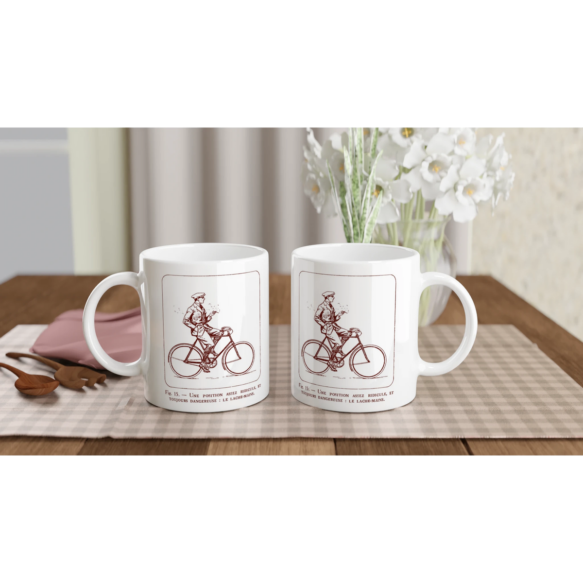 Antica illustrazione di ciclista: Il senza mani. Tazza bianca decorata con un'illustrazione retrò monocroma rossa che raffigura un ciclista in abito che lascia il manubrio, accompagnata dalla didascalia esplicativa 'Une position assez ridicule et toujours dangereuse : le lâche-mains'.