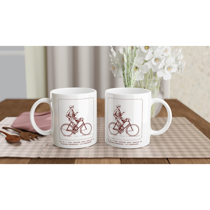 Antica illustrazione di ciclista: Il senza mani. Tazza bianca decorata con un'illustrazione retrò monocroma rossa che raffigura un ciclista in abito che lascia il manubrio, accompagnata dalla didascalia esplicativa 'Une position assez ridicule et toujours dangereuse : le lâche-mains'.