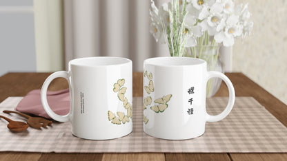 Illustration de papillons blancs et verts - Kamisaka Sekka. Mug blanc orné d'une composition de papillons aux ailes jaune pâle et bordées de vert, avec des motifs subtils et un texte calligraphié en noir. Image d'illustration 2