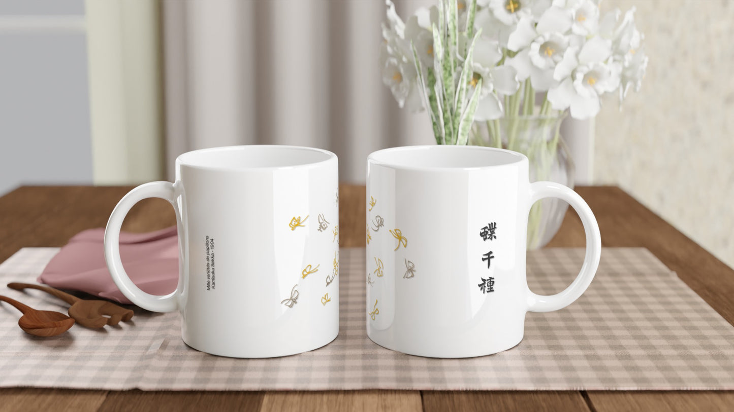 Illustration de papillons gris et dorés, Kamisaka Sekka. Mug blanc orné d'une composition de papillons stylisés aux couleurs grises et dorées, disposés de manière éparse, avec une calligraphie noire sur le côté. Image d'illustration 2