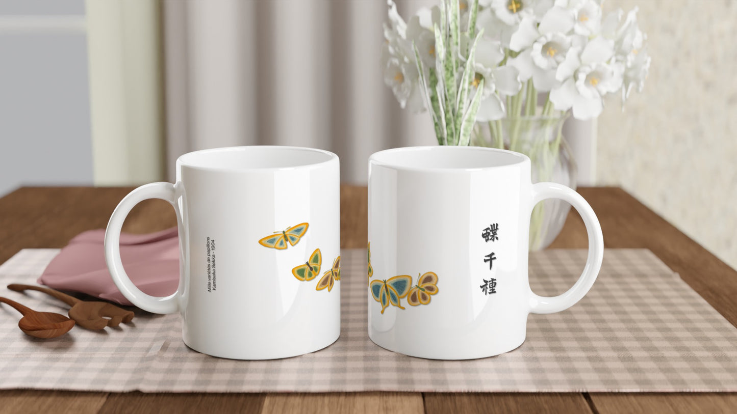 Reproduction d’une estampe de six papillons bleus et or, Kamisaka Sekka. Mug blanc décoré de six papillons aux ailes bleu-gris, ornées de détails jaune doré, disposés en cercle. Un texte calligraphié en noir est présent sur le côté. Image d'illustration 2