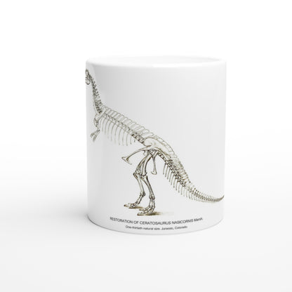 Mug en céramique squelette de Cératosaure gravure U.S. Geological Survey. Mug en céramique blanche illustré d'une gravure scientifique représentant le squelette complet d'un dinosaure cératosaure, accompagnée de la mention U.S. Geological Survey.
