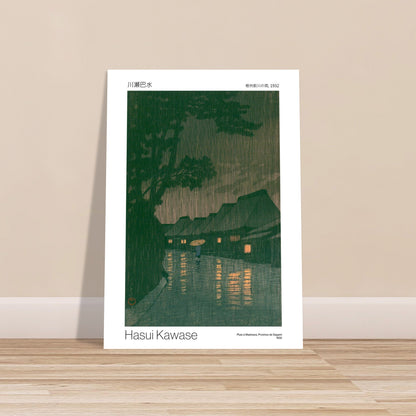Antike Tafel: Regen in Maekawa, Provinz Sagami von Hasui Kawase. Japanischer Holzschnitt von Hasui Kawase, der ein Dorf im Regen mit einer Person mit Regenschirm darstellt.