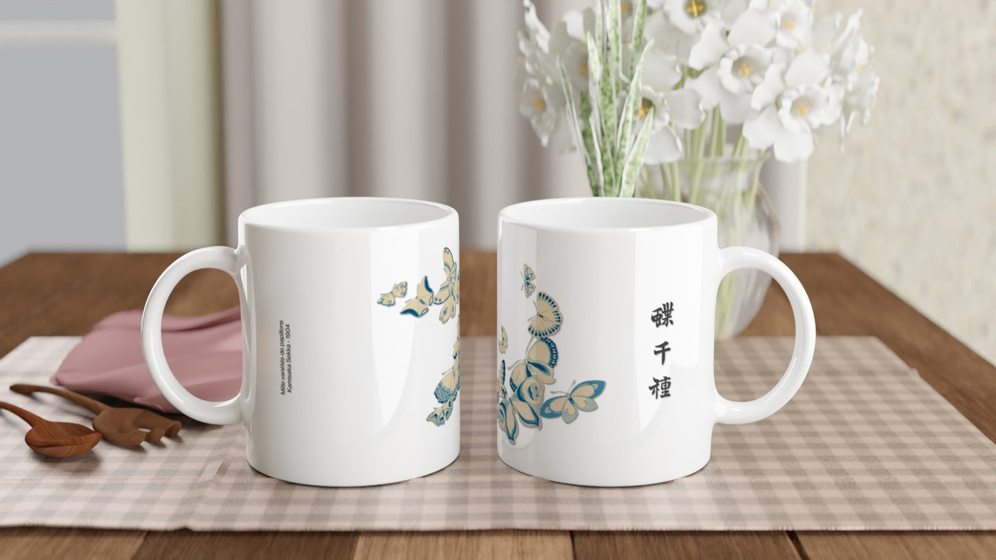 Planche de papillons aux nuances de bleu et beige – Kamisaka Sekka. Une tasse blanche décorée de papillons aux ailes bleues et beiges, rappelant la faïence et les azulejos, avec des inscriptions en japonais. Image d'illustration 2