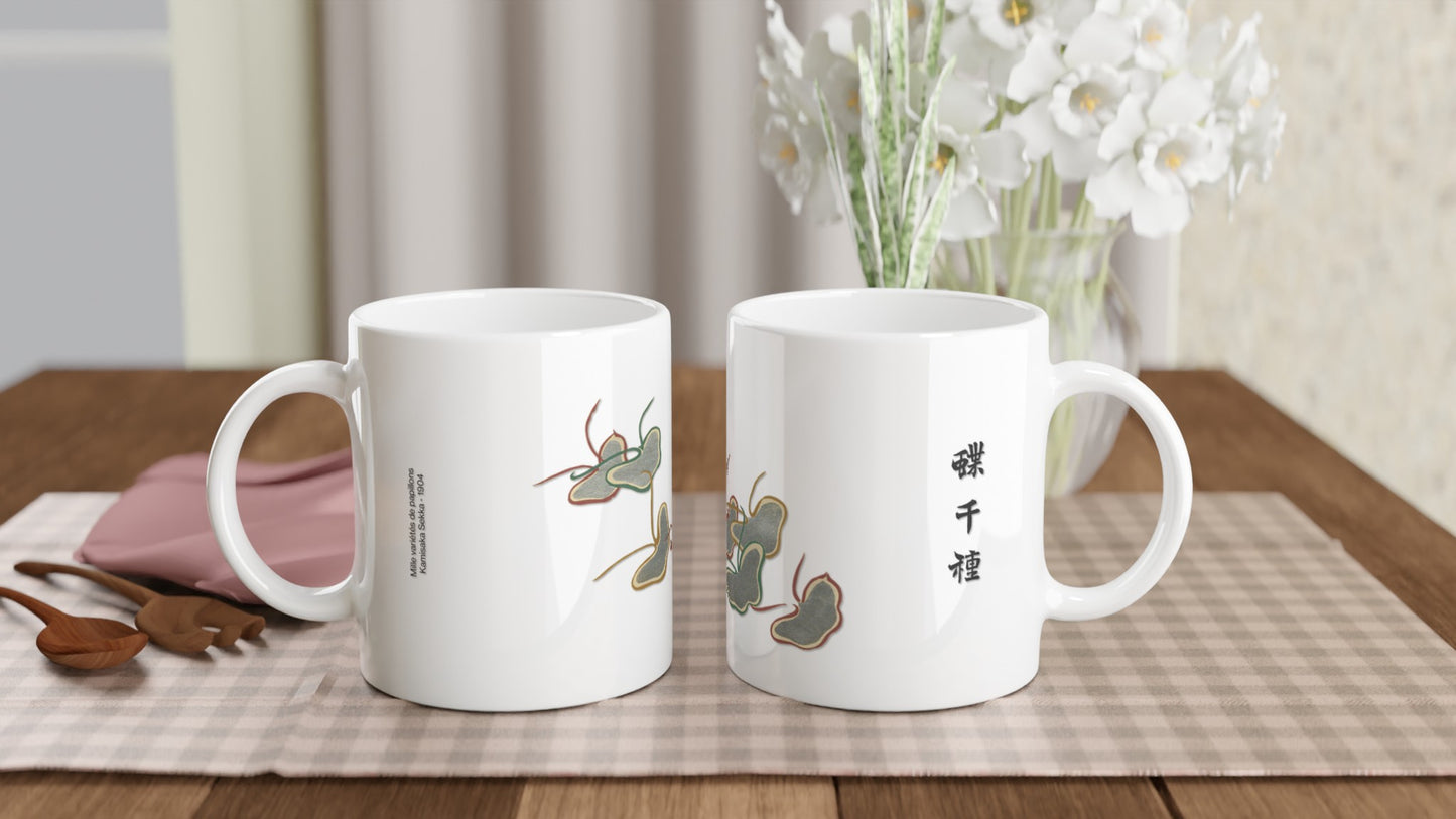 Planche de papillons stylisés gris et dorés - Kamisaka Sekka. Mug blanc présentant des papillons aux formes stylisées et épurées, avec des détails gris et des contours marron et dorés, évoquant des ombres chinoises, accompagnés d'inscriptions japonaises noires. Image d'illustration 2