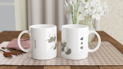 Planche de papillons stylisés gris et dorés - Kamisaka Sekka. Mug blanc présentant des papillons aux formes stylisées et épurées, avec des détails gris et des contours marron et dorés, évoquant des ombres chinoises, accompagnés d'inscriptions japonaises noires. Image d'illustration 2