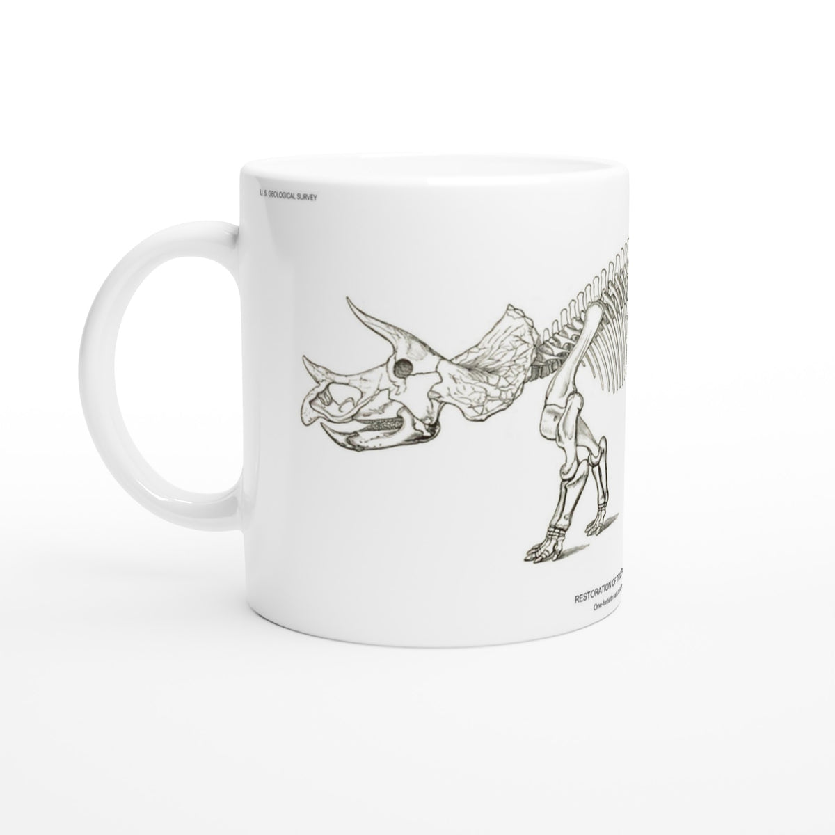 Planche scientifique ancienne du squelette de Triceratops – US Geological Survey. Mug en céramique blanche illustré d'une gravure scientifique représentant le squelette d'un Triceratops avec les mentions US Geological Survey.