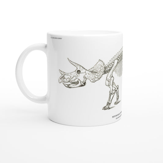 Planche scientifique ancienne du squelette de Triceratops – US Geological Survey. Mug en céramique blanche illustré d'une gravure scientifique représentant le squelette d'un Triceratops avec les mentions US Geological Survey.