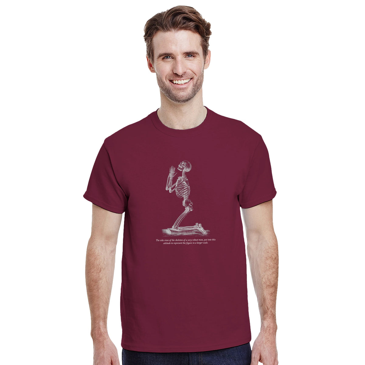 Kneeling Male Skeleton Anatomy T-shirt - Cheselden. Burgundy t-shirt featuring a white line drawing of a male skeleton kneeling in prayer.